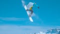 Male snowboarder flies through the air and does a spinning nose grab