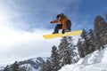 Male Snowboarder Jumping Over Snow Covered Hill Royalty Free Stock Photo