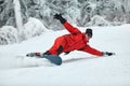 Male snowboarder in a red suit rides on the snowy hill with snowboard, Skiing and snowboarding concept