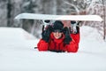 Male snowboarder in a red suit walking on the snowy hill with snowboard, Skiing and snowboarding concept