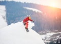 Male snowboarder riding from the top of the snowy hill with snowboard at winter ski resort Royalty Free Stock Photo