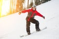 Male snowboarder slides down from the mountain in winter day