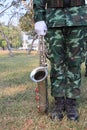 Male soldiers standing holding saxophone instruments, grass background