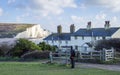 A male solo hiker looking at road sign in front of the houses near England Seven Sisters cliffs