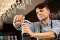 Male sommelier open wine bottle with corkscrew. Royalty Free Stock Photo