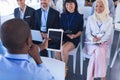 Male speaker with digital tablet speaks in business seminar at conference meeting Royalty Free Stock Photo