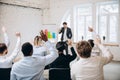 Male speaker giving presentation in hall at workshop. Audience or conference hall. Rear view of unrecognized Royalty Free Stock Photo