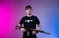 a male special agent with an automatic airsoft rifle on a neon background Royalty Free Stock Photo