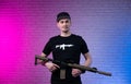 a male special agent with an automatic airsoft rifle on a neon background