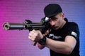 a male special agent with an automatic airsoft rifle on a neon background Royalty Free Stock Photo