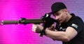 a male special agent with an automatic airsoft rifle on a neon background Royalty Free Stock Photo