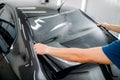 Male specialist with car tinting film in hands