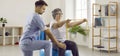 Physiotherapist helping senior woman with osteoporosis do rehabilitation exercises on fit ball Royalty Free Stock Photo