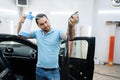 Male specialist with spray wetting car tinting Royalty Free Stock Photo
