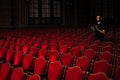 A male spectator in an empty concert hall applauds standing Royalty Free Stock Photo