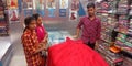 male staff showing clothes to the female customer at showroom in India