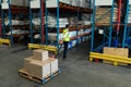 Male staff using pallet jack in warehouse