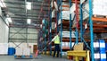 Male staff using pallet jack in warehouse Royalty Free Stock Photo