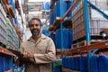 Male staff writing on clipboard standing in warehouse Royalty Free Stock Photo