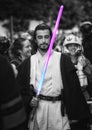 Male standing in a crowd holding a lightsaber during the fest Fuenlabrada - Star wars, 501st legion