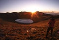 A male standing on a higher place by the Jiaming lake , and waiting for the beautiful sunrise. Ready to take some photos.