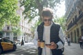 Male startupper in casual clothes and sunglasses typing on his smartphone