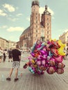 Male street vendor sells colorful popular cartoon character helium balloons