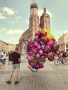 Male street vendor sells colorful popular cartoon character helium balloons