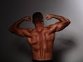 Male strong sportsman flexing his arms biceps on dark background. Royalty Free Stock Photo