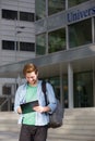 Male student on campus writing on notepad