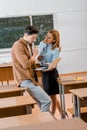 Male student and female teacher in formal wear using laptop during lesson Royalty Free Stock Photo