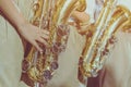 Male student with friends blow the saxophone with the band for performance on stage Royalty Free Stock Photo