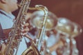 Male student with friends blow the saxophone with the band for performance on stage Royalty Free Stock Photo