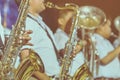 Male student with friends blow the saxophone with the band for performance on stage