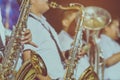 Male student with friends blow the saxophone with the band for performance on stage Royalty Free Stock Photo