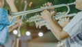 Male student with friends blow the trumpet with the band for performance on stage