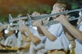 Male student with friends blow the trumpet with the band for performance on stage
