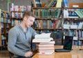 Male student reading book in library Royalty Free Stock Photo