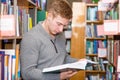 Male student reading book in library Royalty Free Stock Photo