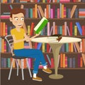 Male student reads textbook sitting at the table in college library