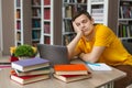 Male student sleeping at workplace in college library Royalty Free Stock Photo