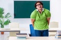 Male student suffering from urge in the classroom