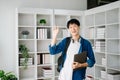 Male student taking notes from a book at library, Young asian sitting at desk doing assignments in college library Royalty Free Stock Photo