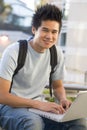 Male student using laptop outside