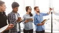 Male student writing on whiteboard in classroom, classmates taking notes Royalty Free Stock Photo