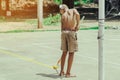 Male students use small paint rollers to paint yellow lines on the cement floor for Sepak Takraw