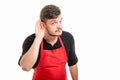 Male supermarket employer showing ear like not hearing