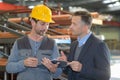 Male supervisor talking with worker in metal industry