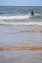 Male surfer in a black swim suit in the ocean with blue surfboard. Warm day, Beautiful cloudy sky, Nature scene. Atlantic ocean, Royalty Free Stock Photo