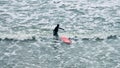 Male surfer in black swimsuit with red surfboard in sea waves Royalty Free Stock Photo